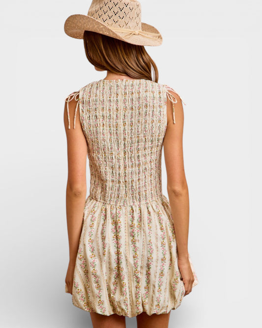 Woman wearing a floral dress and straw hat on a plain background