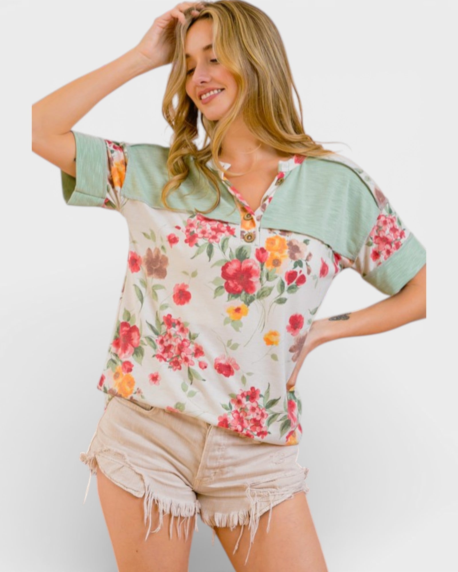 Woman wearing a floral blouse with green sleeves on a white background