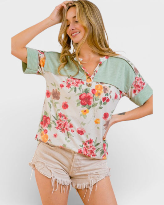 Woman wearing a floral blouse with green sleeves on a white background