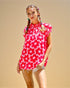Young girl wearing a pink floral dress against a beige background