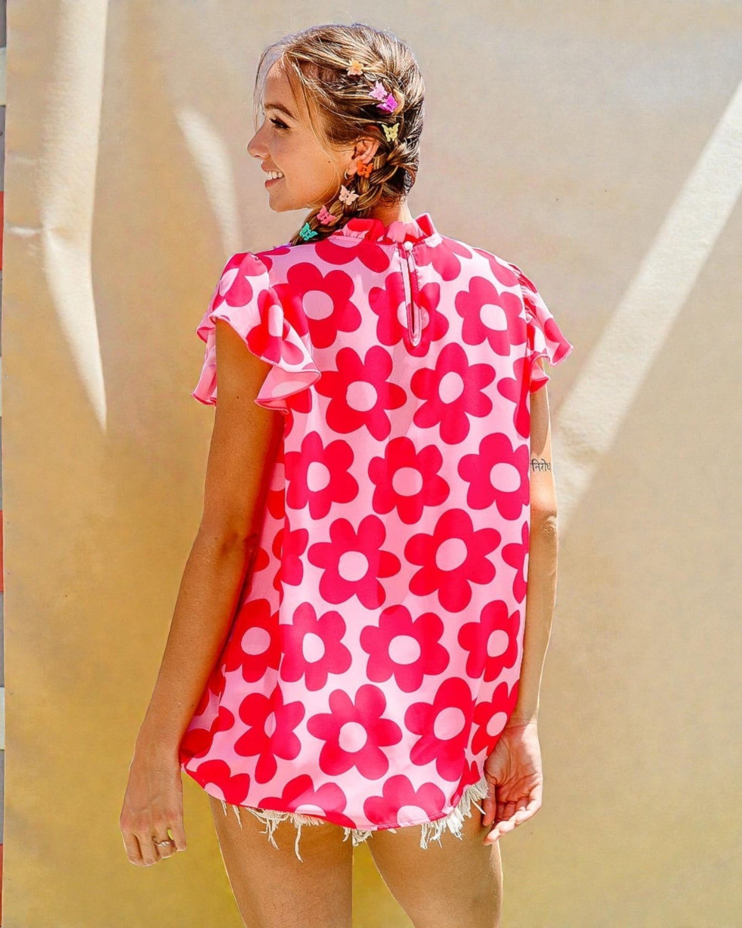 Woman wearing a pink floral dress against a neutral background