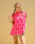 Woman wearing a pink floral dress against a beige background