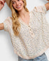 Woman wearing a floral blouse with a plain background