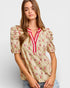 Woman wearing a floral blouse with a plain background