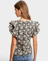 Woman wearing a floral blouse with ruffled sleeves on a white background
