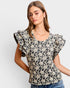 Woman wearing a floral blouse with ruffled sleeves on a white background