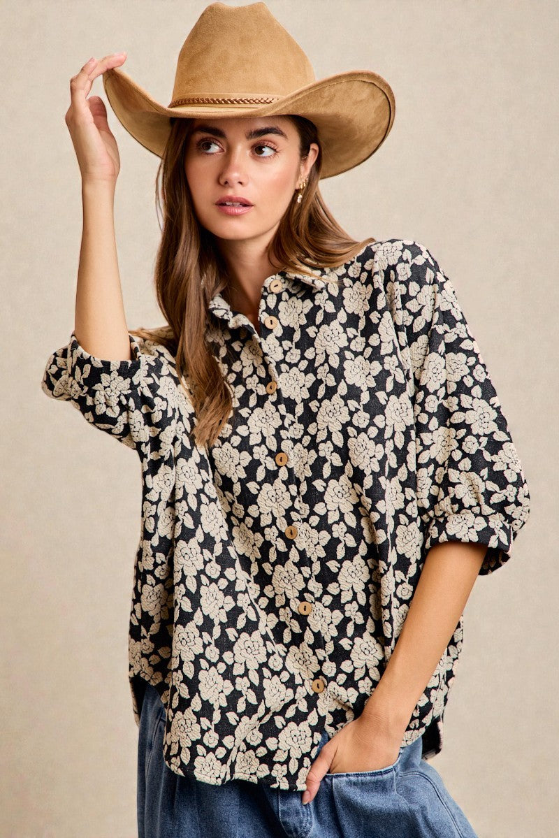 Woman wearing a floral blouse and cowboy hat against a beige background