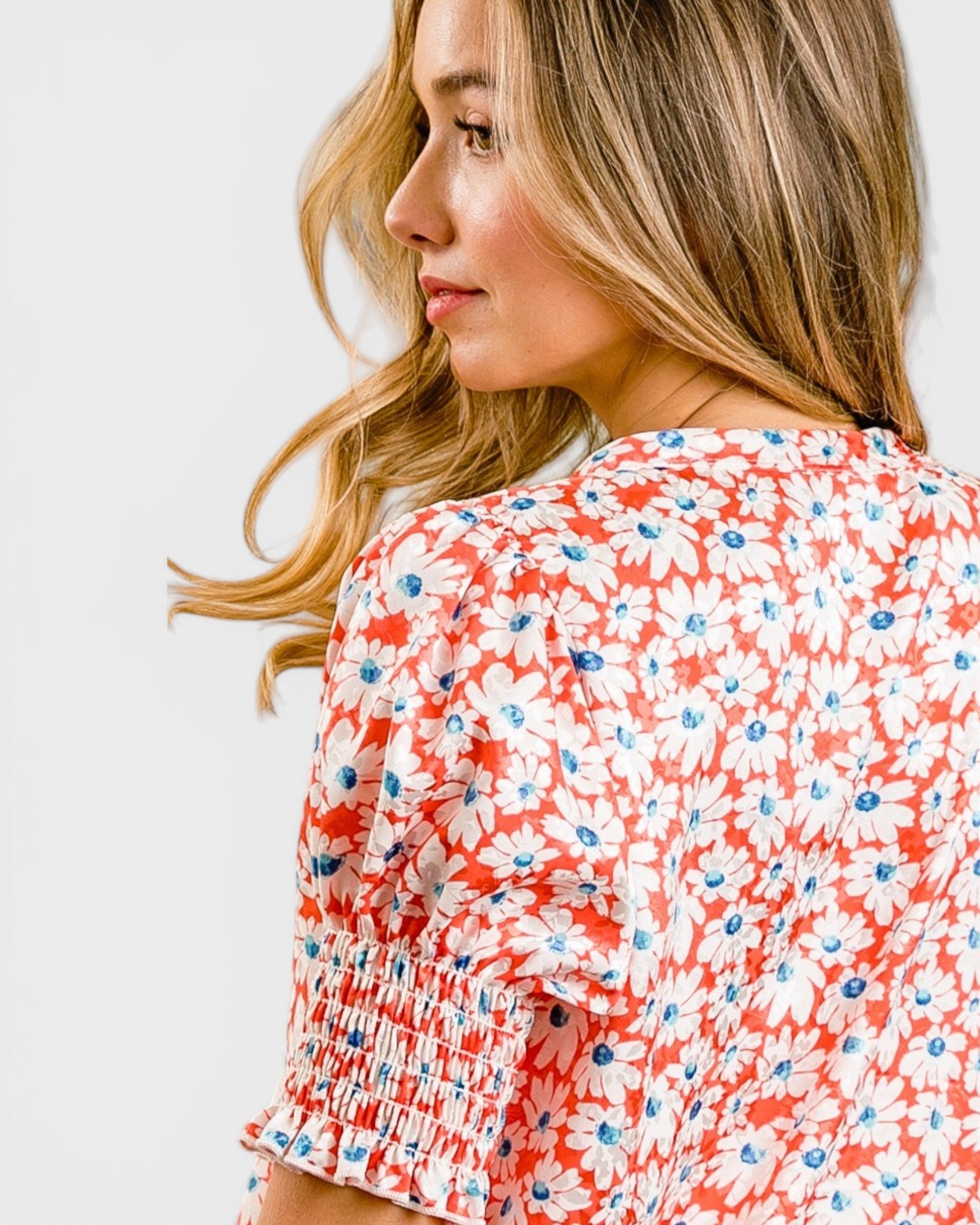 Woman wearing a red floral blouse on a white background