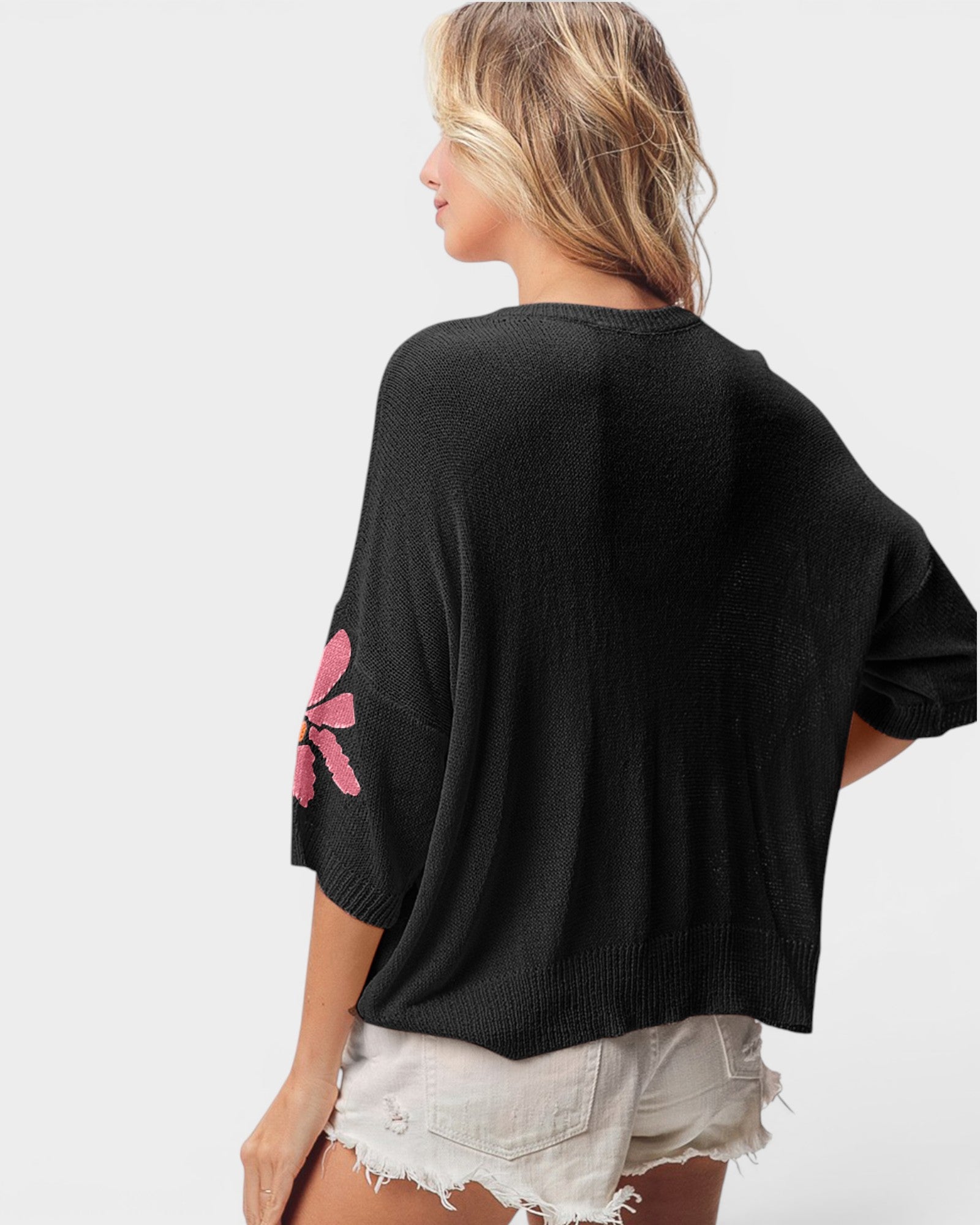 Suéter corto con estampado floral fucsia rosa en negro