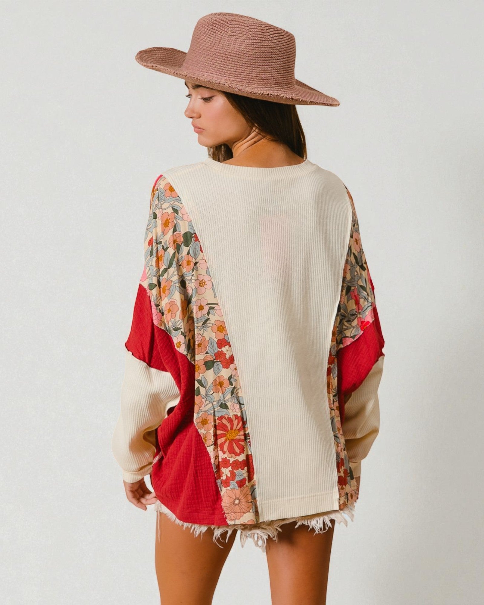 Woman wearing a colorful poncho with a neutral sweater underneath on a white background