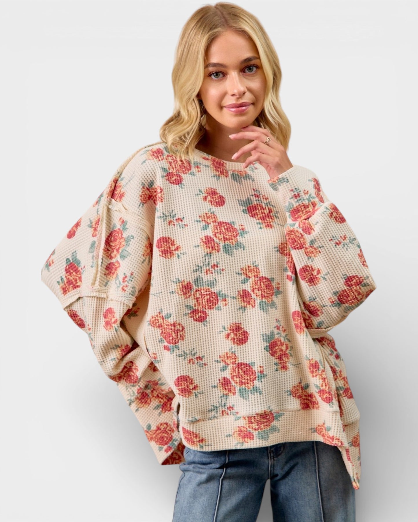 Woman wearing a floral patterned sweater against a white background