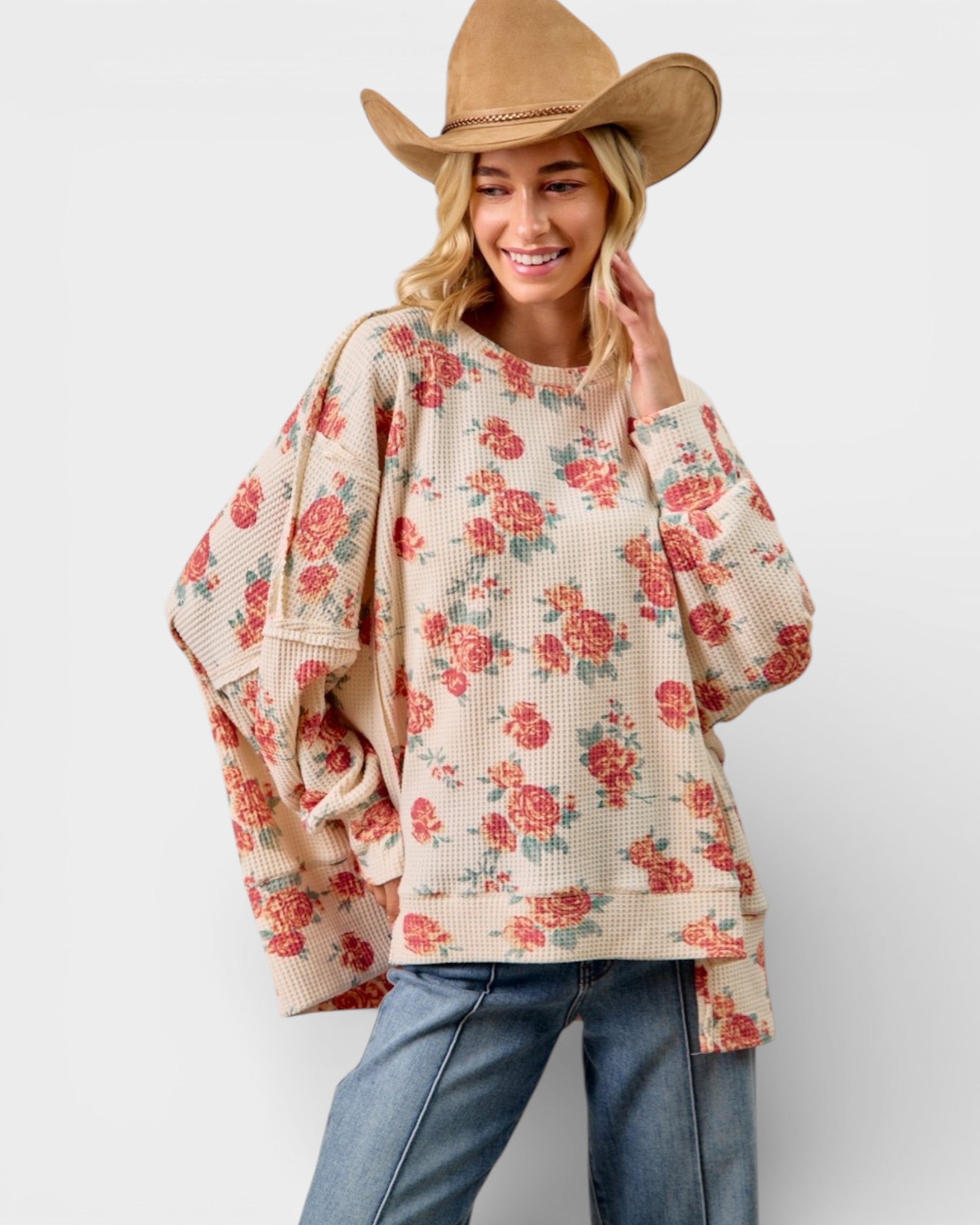 Woman wearing a floral sweater and cowboy hat on a white background