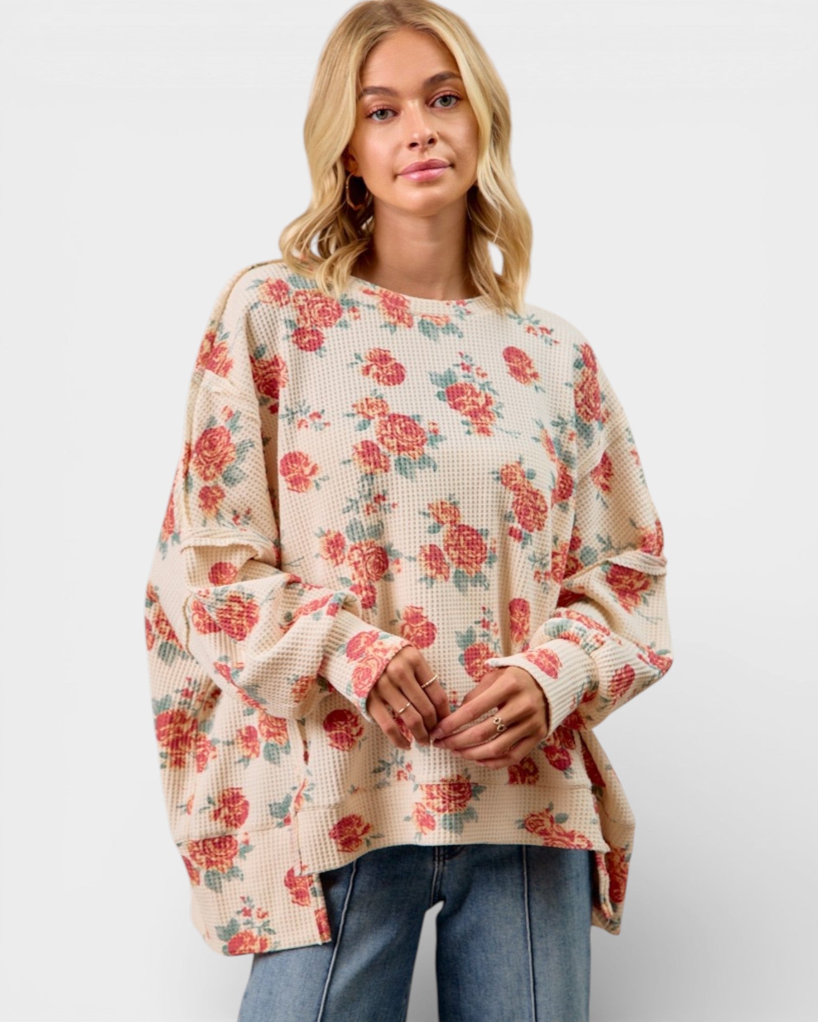 Woman wearing a floral sweater with a plain background