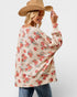 Woman wearing a floral sweater and wide-brimmed hat on a plain background