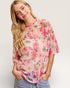 Woman wearing a floral blouse with a plain background