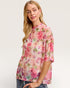 Woman wearing a floral blouse with a plain background