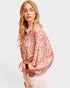 Woman wearing a floral blouse with a plain background