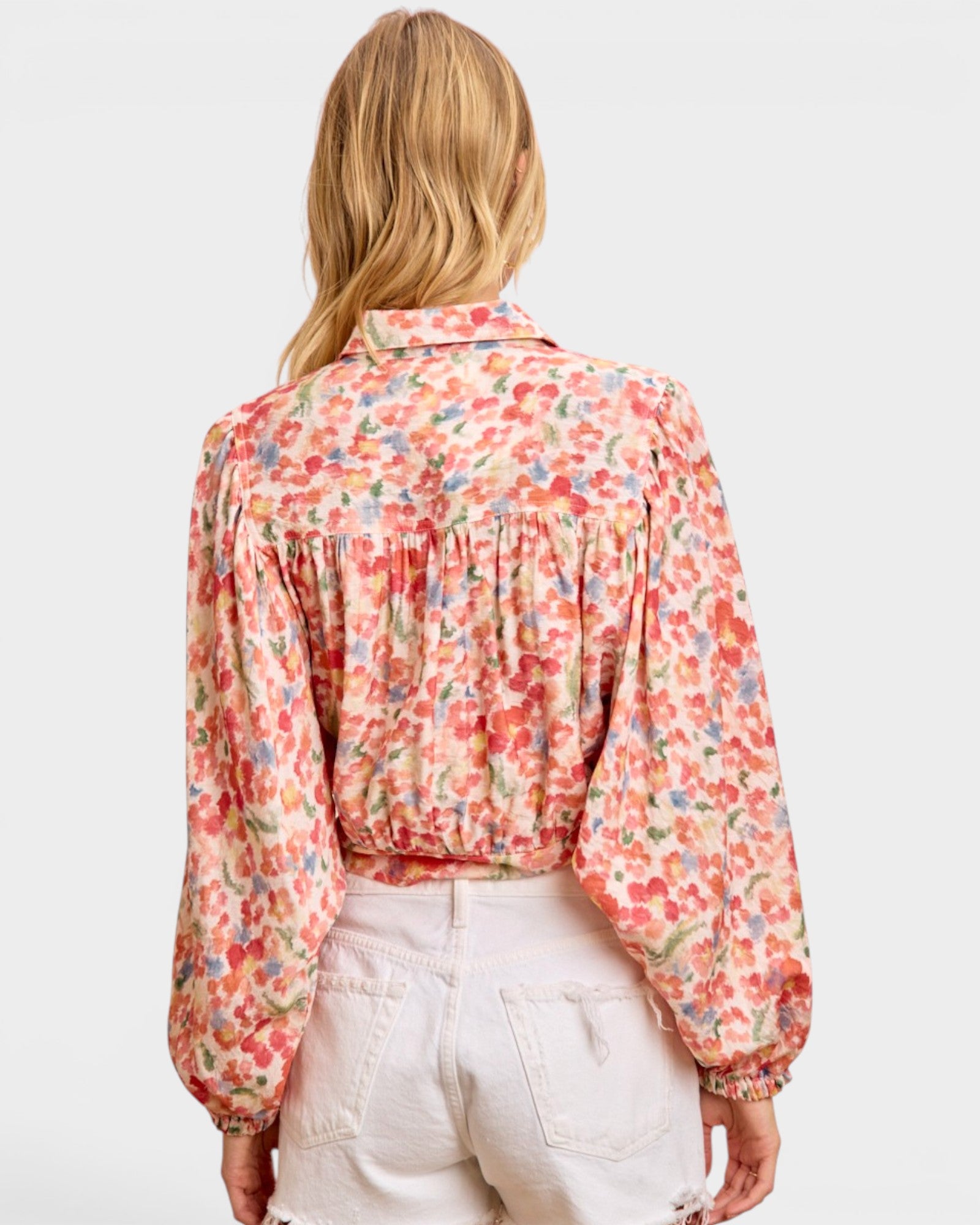 Person wearing a floral blouse with a plain background