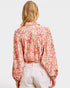 Person wearing a floral blouse with a plain background