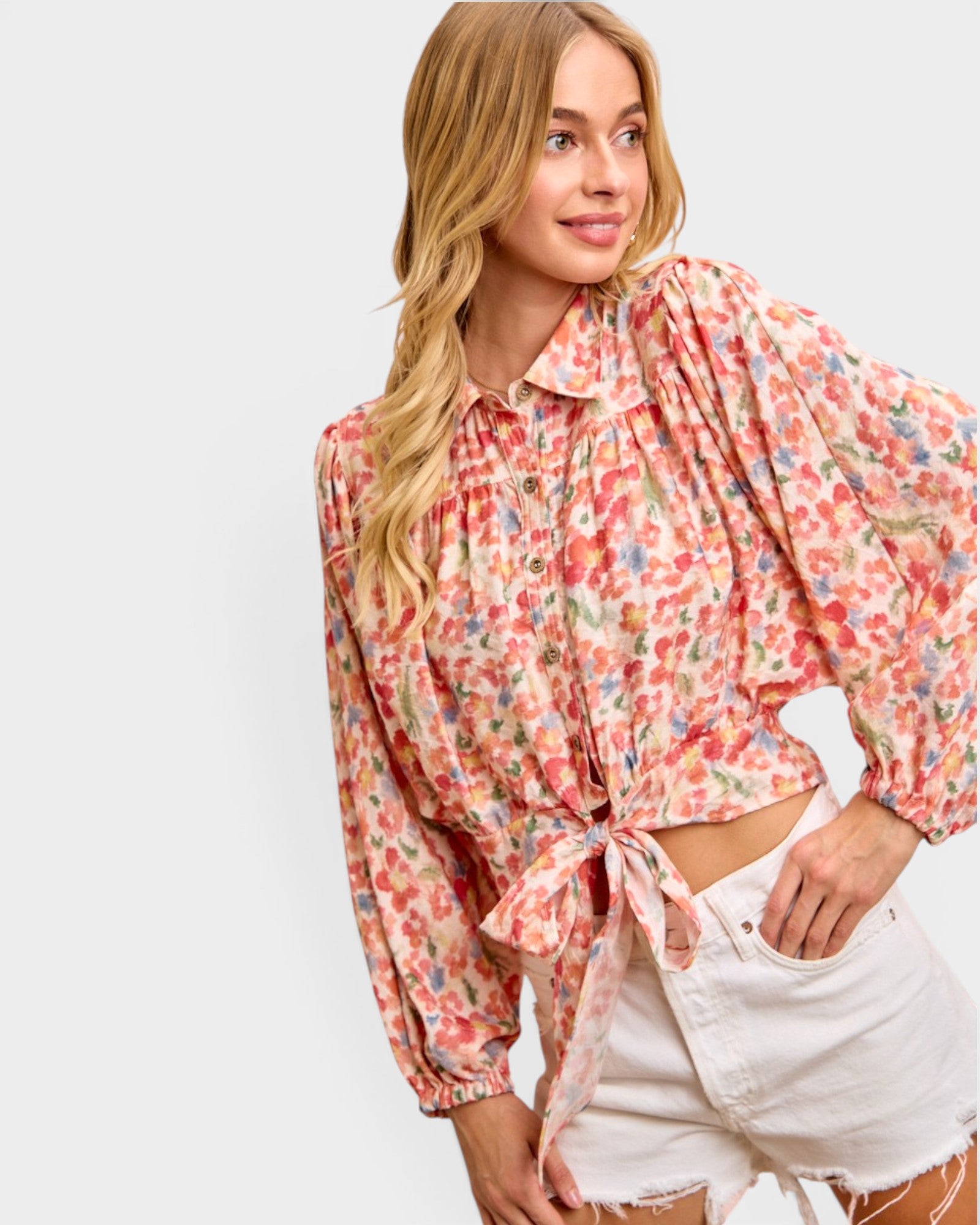 Woman wearing a floral blouse with rolled-up sleeves on a white background