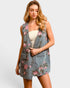 Woman wearing a floral denim vest over a white top on a plain background
