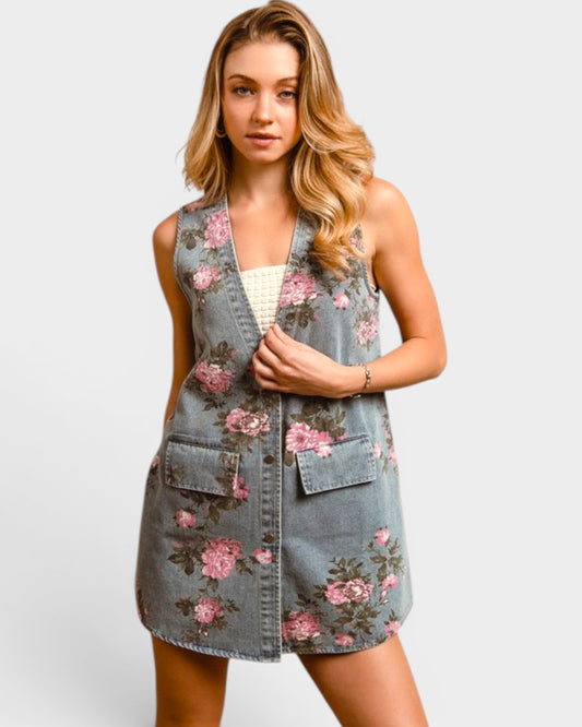 Woman wearing a floral denim vest over a white top on a light gray background