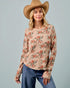 Woman wearing a floral long-sleeve top and wide-brimmed hat against a gray background