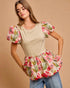 Woman wearing a beige top with floral sleeves and bottom on a beige background