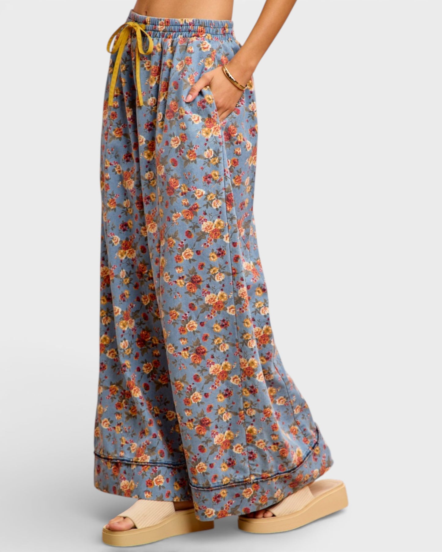 Floral patterned pants worn by a person on a plain background