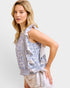Woman wearing a floral blouse with ruffled sleeves on a white background