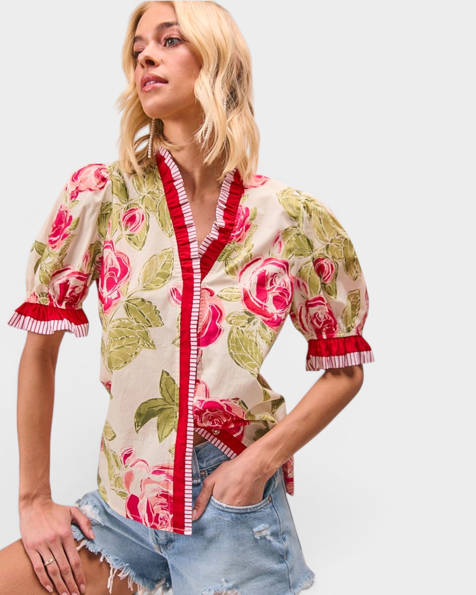 Woman wearing a floral blouse with puff sleeves against a plain background