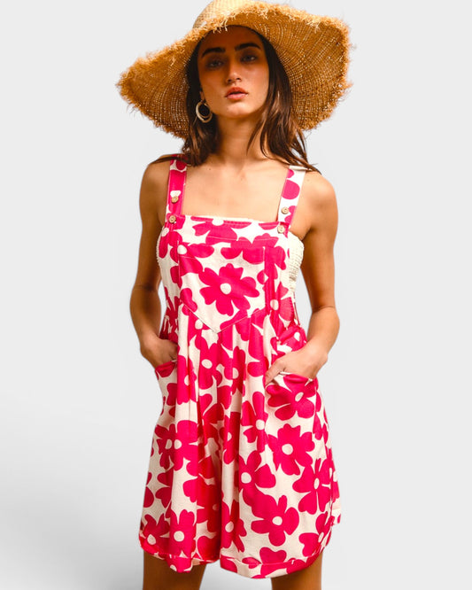 Woman wearing a pink floral dress and straw hat on a light gray background