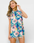 Woman wearing a colorful floral dress against a white background