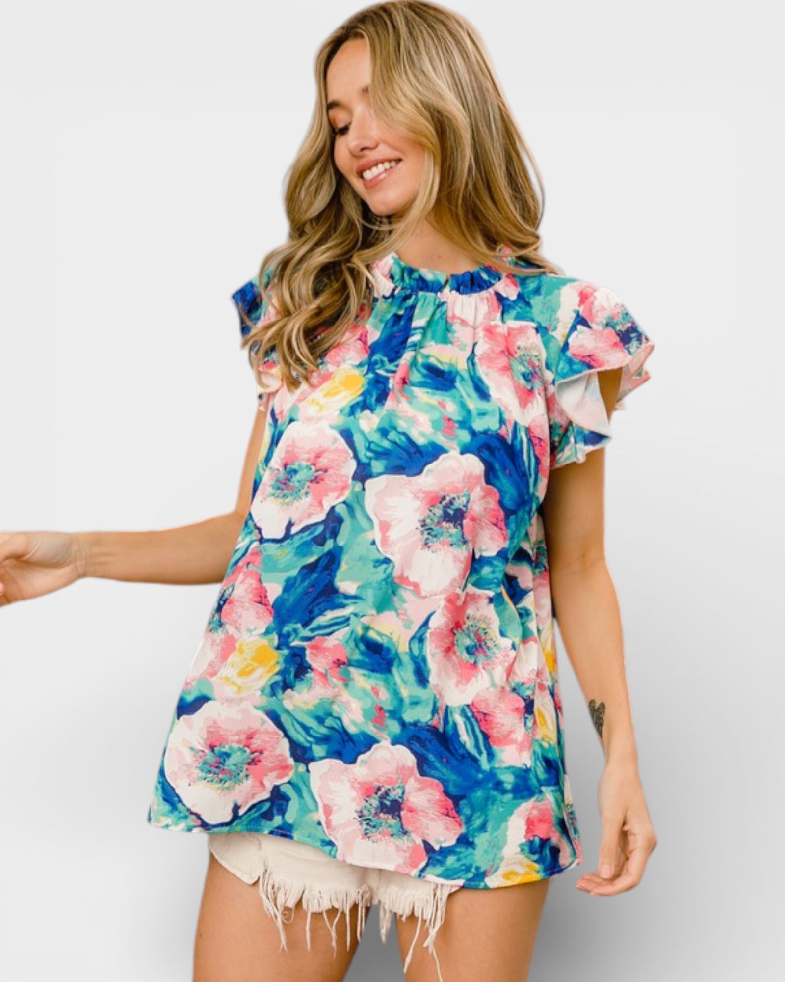 Woman wearing a colorful floral dress against a plain background