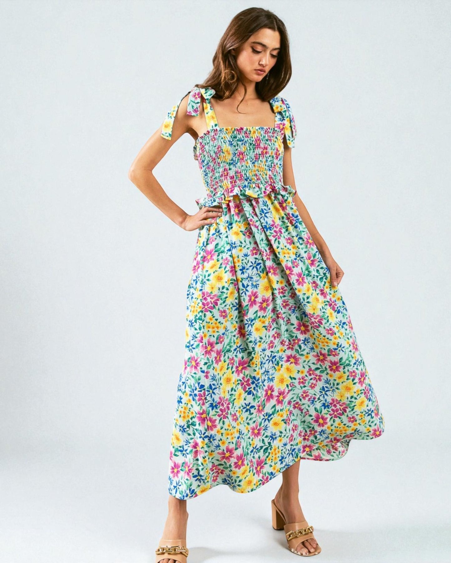 Woman wearing a colorful floral dress on a white background
