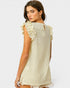 Woman wearing a light-colored sleeveless top with ruffled details on a white background