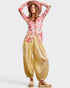 Woman wearing a floral top and wide-leg pants with a hat on a white background