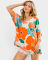 Woman wearing a colorful floral dress against a white background