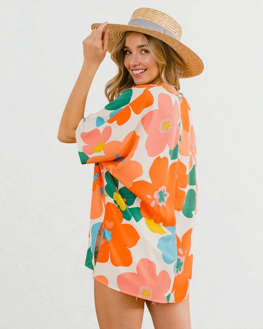 Woman wearing a colorful floral dress and straw hat on a white background