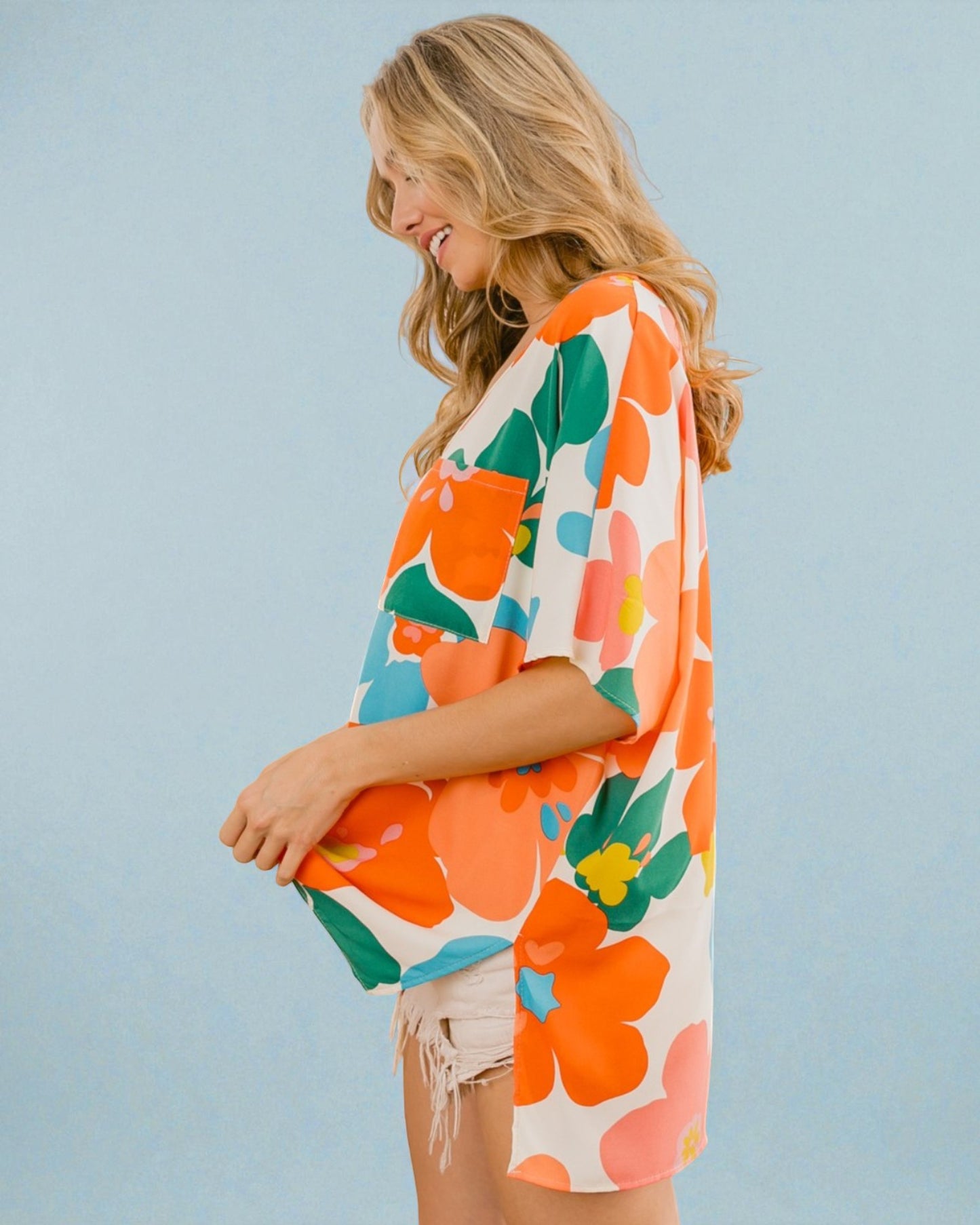 Woman wearing a colorful floral dress against a light blue background