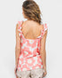 Woman wearing a pink floral tank top on a white background