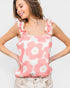 Woman wearing a pink floral tank top against a white background