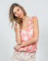 Woman wearing a pink floral tank top against a white background