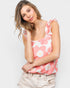 Woman wearing a pink floral tank top against a white background