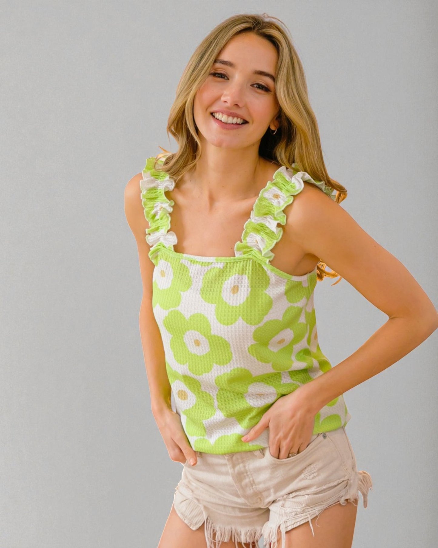 Woman wearing a green floral tank top against a gray background