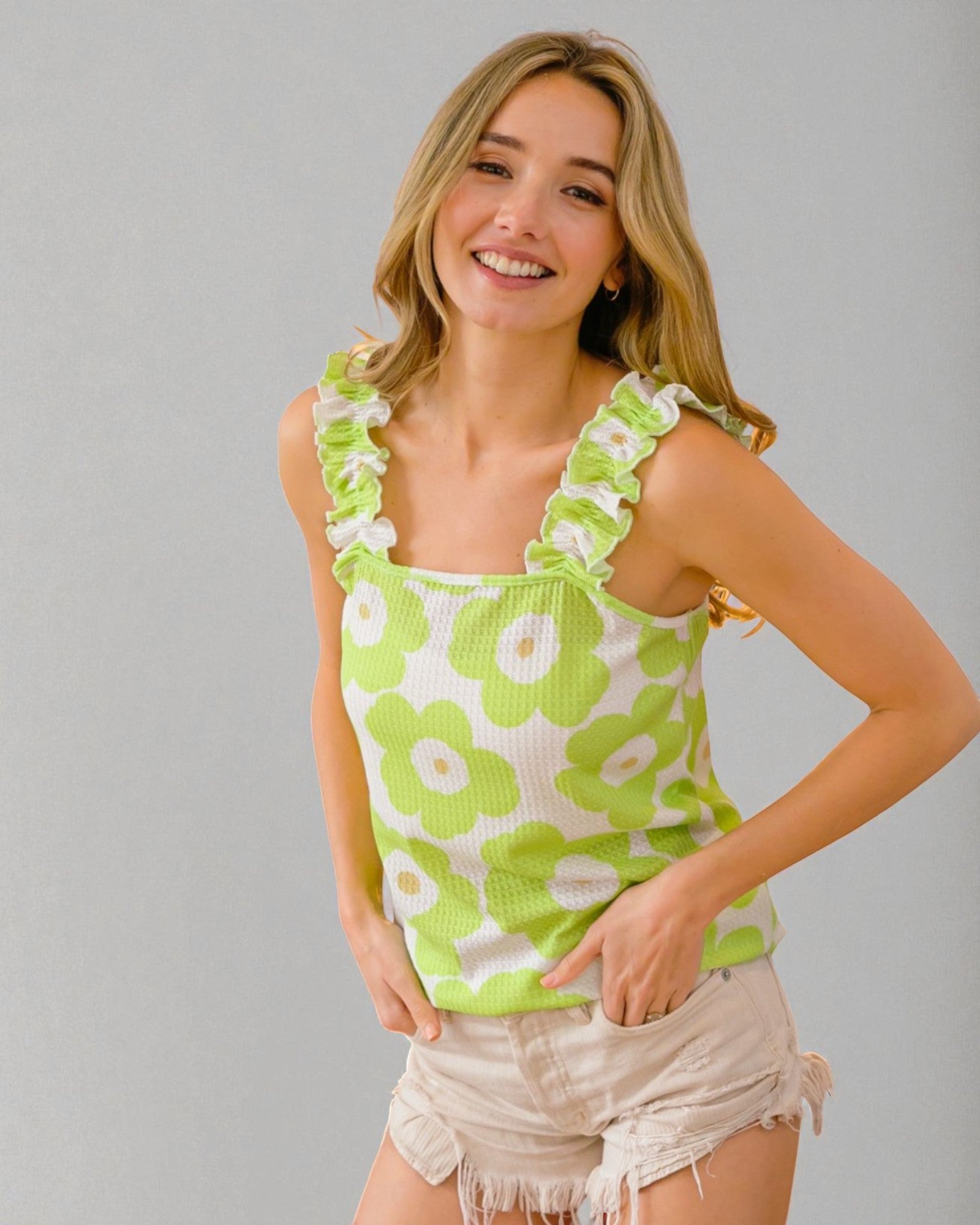 Woman wearing a green floral tank top against a gray background