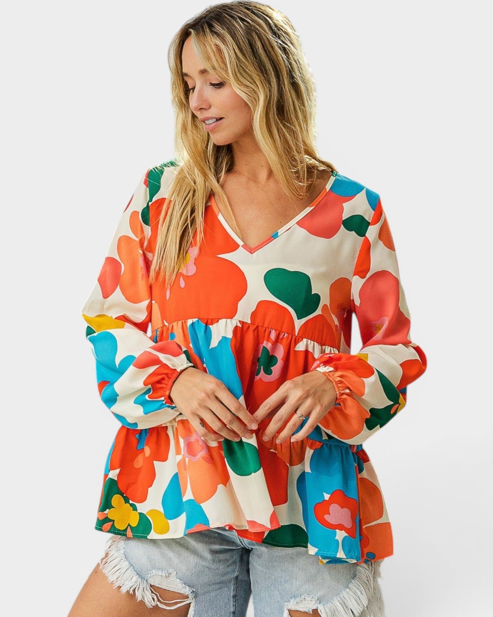 Woman wearing a colorful floral blouse against a white background