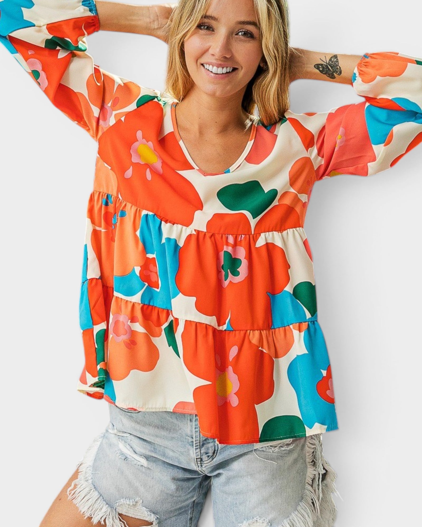 Woman wearing a colorful floral blouse with a plain background