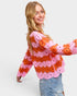 Woman wearing a pink and orange patterned sweater on a white background