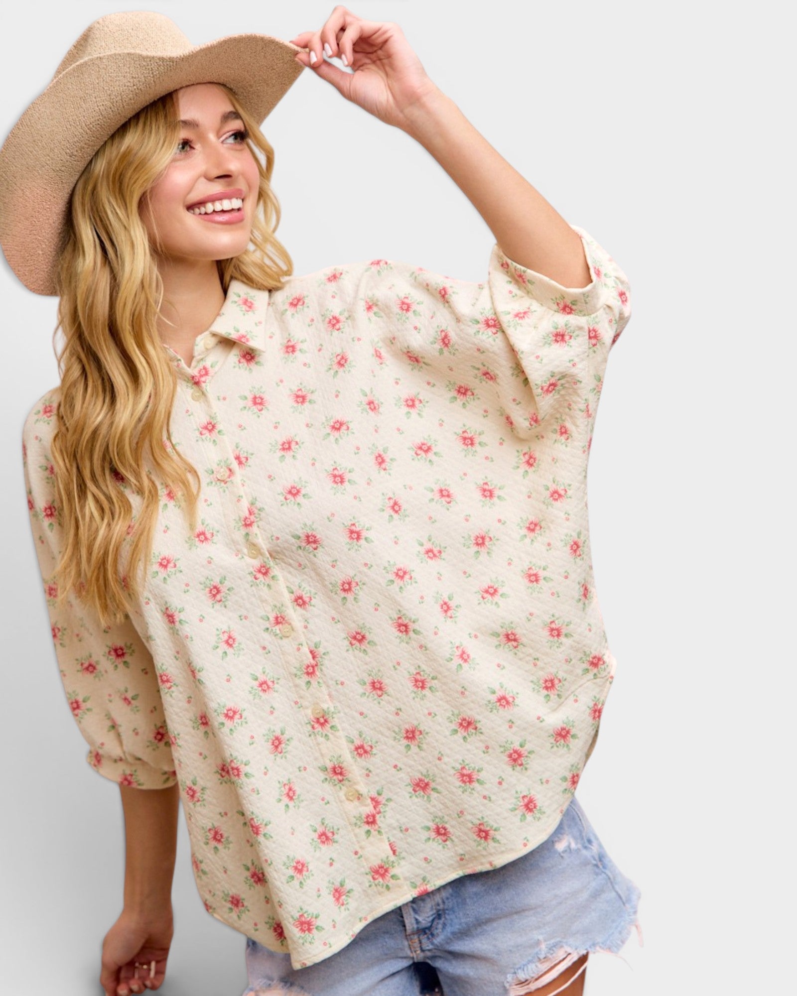 Woman wearing a floral blouse and cowboy hat on a white background